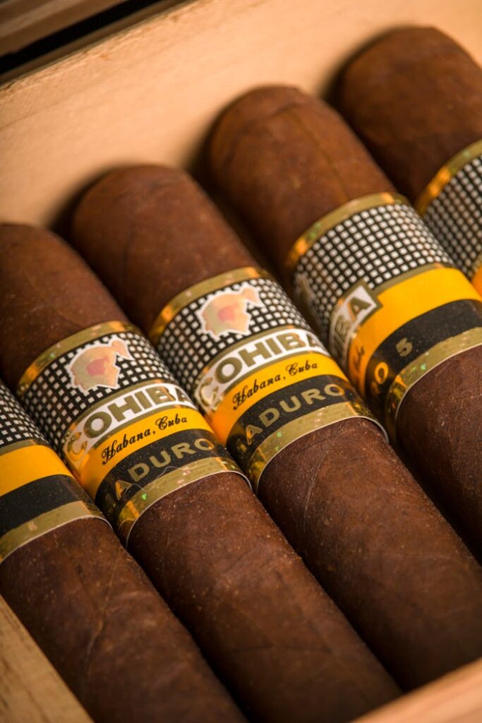 A close-up shot of premium Cohiba cigars in a wooden box, showcasing their labels and rich texture.
